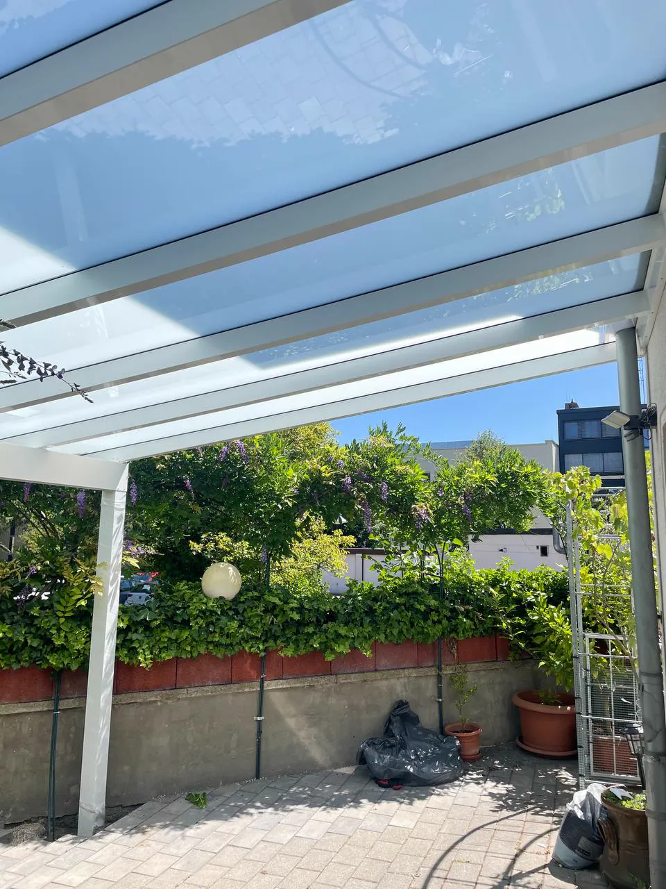 Unteransicht einer weißen Terrassenüberdachung mit lichtdurchlässiger Dacheindeckung